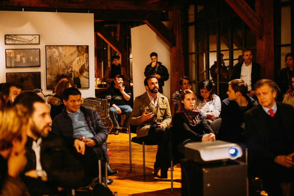 An audience watching a presentation being given in a gallery setting, you'll want to know how to give a presentation in any setting!