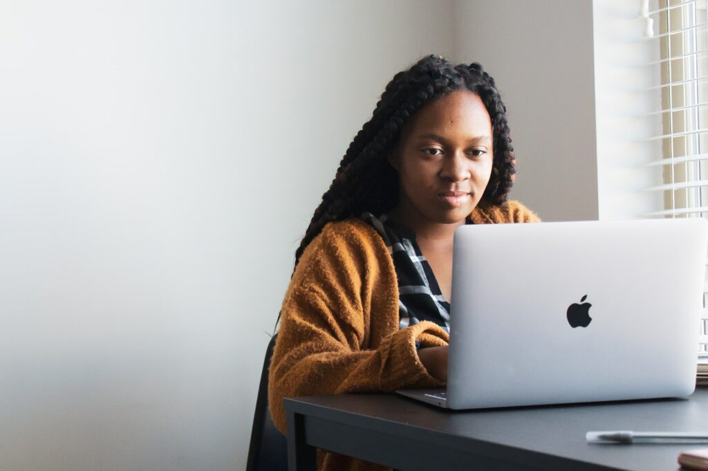 A person sat at a desk using a laptop could be a good setup for a hybrid office.