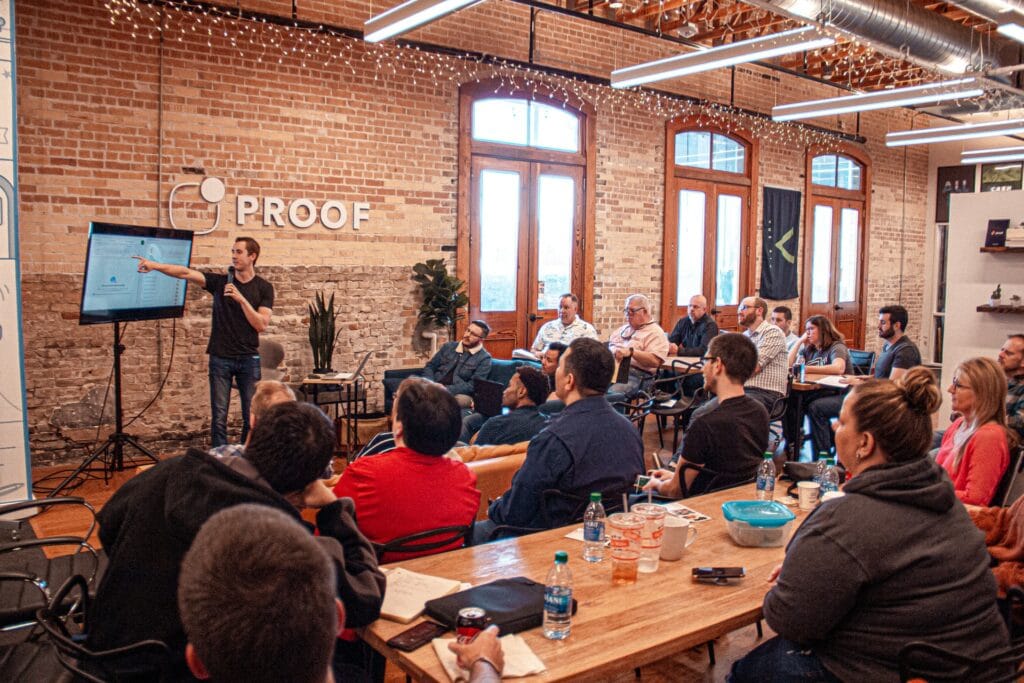 Someone giving a presentation in front of a screen after learning how to make a presentation interesting.