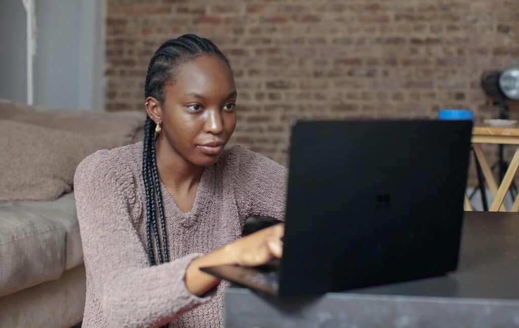 A person works on there laptop from home with the help of remote team management.